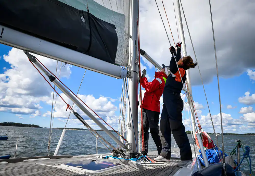 Instructor adjusting the rigging on a sailboat