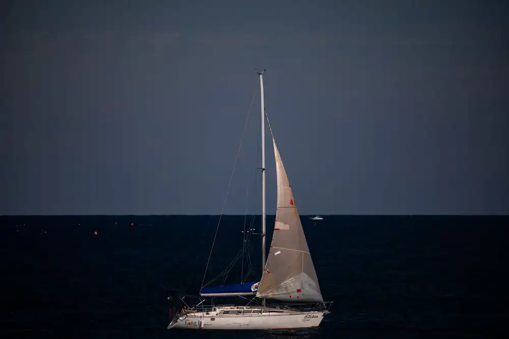 Sailing boat on open water at sunset